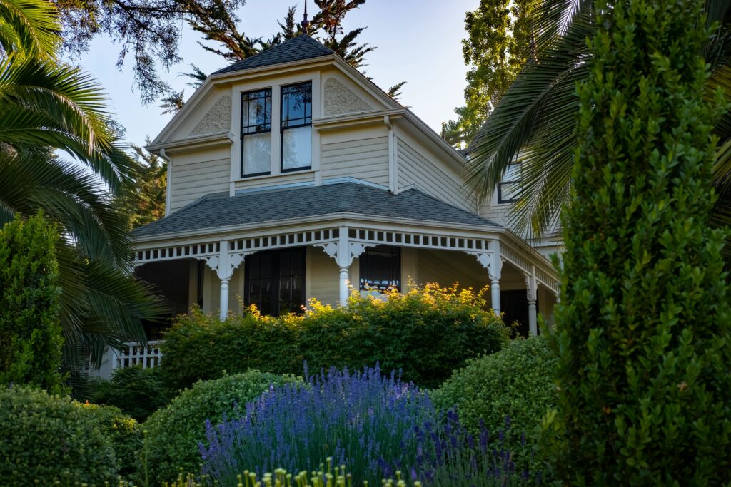 A beautiful Victorian-style house surrounded by a vibrant and lush garden.
