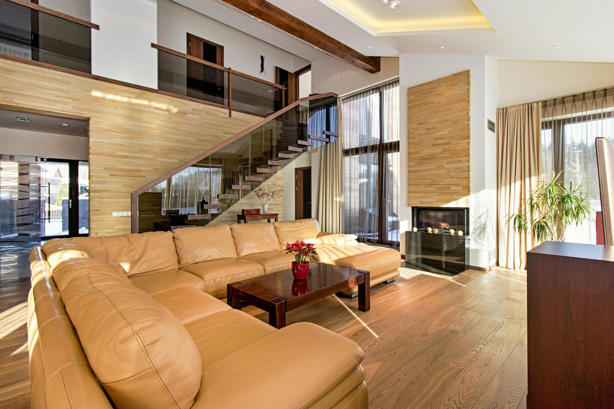 Spacious modern living room with leather sofa and wooden accents.